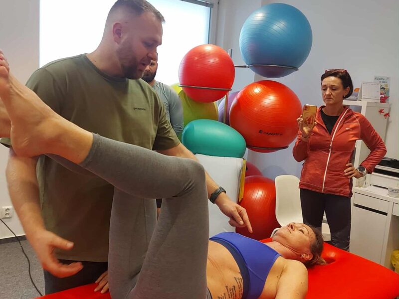 Lektor predvádza praktické nastavenie dolných končatín v polohe na chrbte na kurze DNS – Dynamická neuromuskulárna stabilizácia v Košiciach.