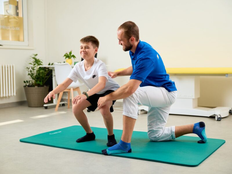 Fyzioterapeut koriguje techniku drepu dieťaťa počas individuálneho tréningu FyzioFitness pre deti v Košiciach.