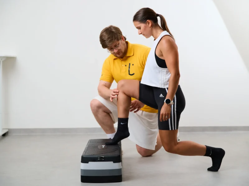 Nácvik výpadu na step platforme pod dohľadom trénera Privilio – fyziofitness tréning zameraný na stabilitu kolena.