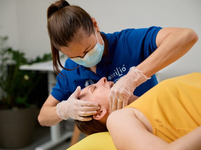 Fyzioterapeutka vykonáva intraorálne vyšetrenie žuvacích svalov a sánkového kĺbu klientky počas vstupného vyšetrenia fyzioterapie sánky (TMJ) v Košiciach.
