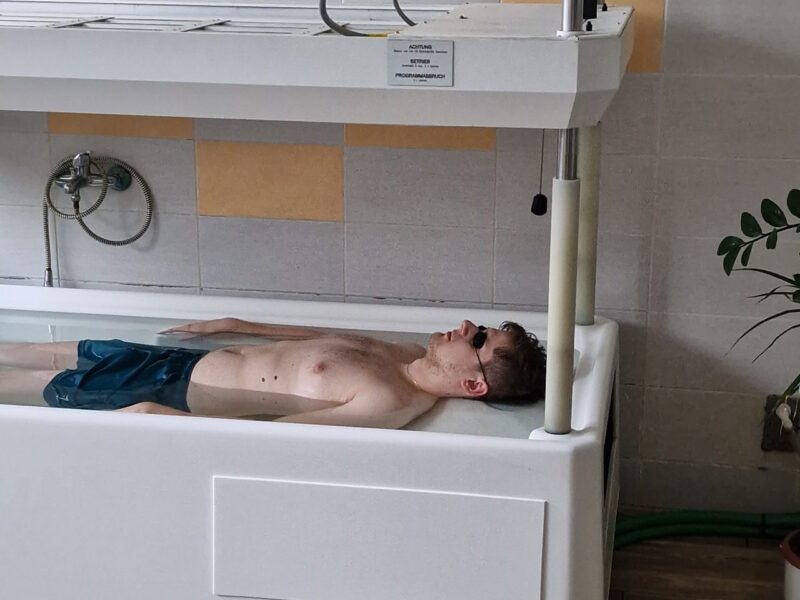 Pacient počas synchrónnej balneofototerapie v zariadení TOMESA na liečbu kožných ochorení.
